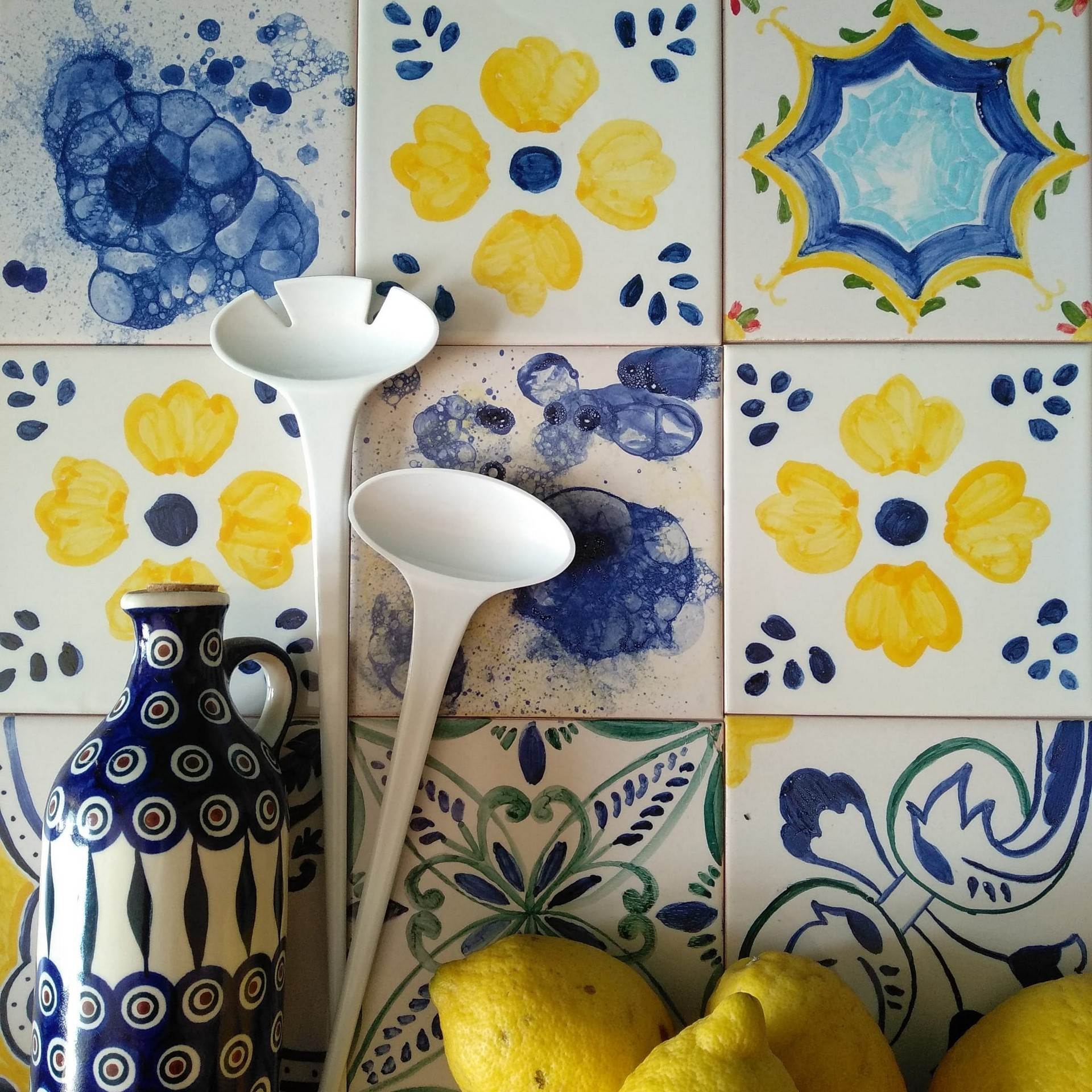 Ściana kuchenna z kaflami żółto-niebiesko-zielonymi, ceramika Bolesławiec i cytryny