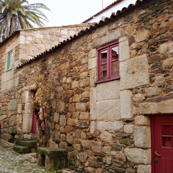 Typowa portugalska wioska w Baira Baixa, kamienny dom z czerwonymi drzwiami