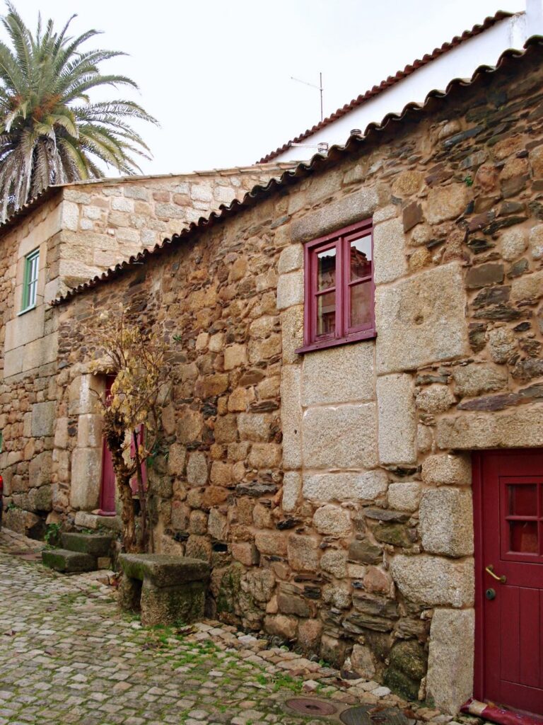 Typowa portugalska wioska w Baira Baixa, kamienny dom z czerwonymi drzwiami