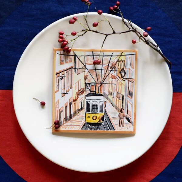 Kafelek z ręcznie malowanym widokiem Lizbony i z charakterystycznym żółtym tramwajem