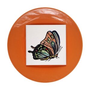 Kolorowy motyl namalowany na kafelku