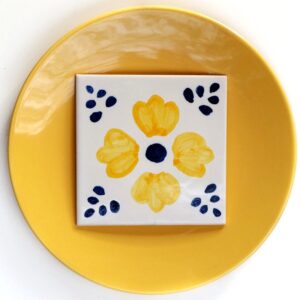 ornament z żółtym kwiatem namalowany ręcznie na kafelku ceramicznym