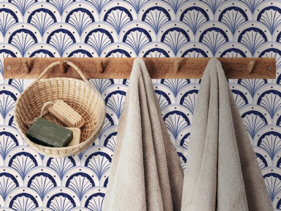 ręczniki wiszące na ścianie odzdobionej kafelkami w kształcie rybiej łuski