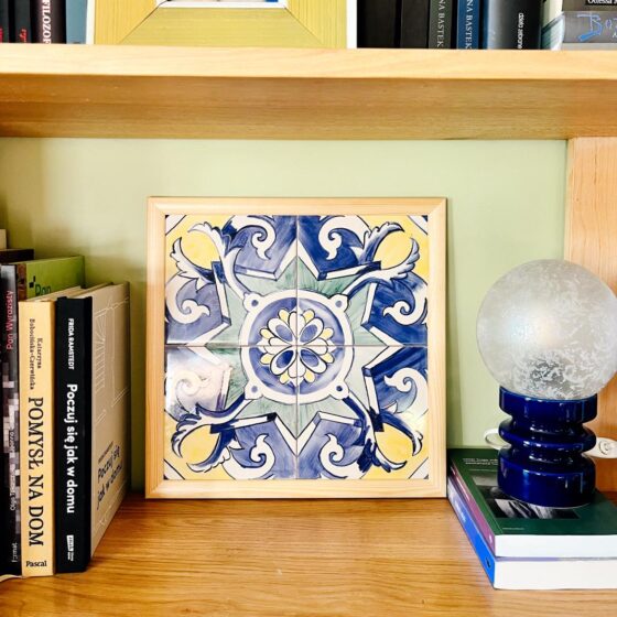 Obrazek z azulejos w ramce, na regale wśród książek, wzór Estrela