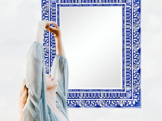 kobieta w zwiewnej sukni przeciągająca się przed lustrem o malowanej ramie z kafli ceramicznych - tak mogą wyglądać poranki jeśli zadbasz o lustro w łazience