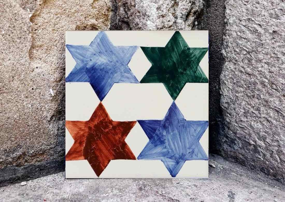 Cztery kolorowe gwiazdki namalowane na kafelku ceramicznym to świetny pomysł na prezent świąteczny