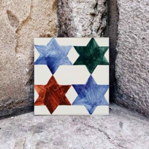 Cztery kolorowe gwiazdki namalowane na kafelku ceramicznym to świetny pomysł na prezent świąteczny