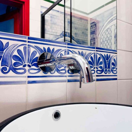 Kafelki ręcznie malowane z ornamentalnym wzorem nad umywalką