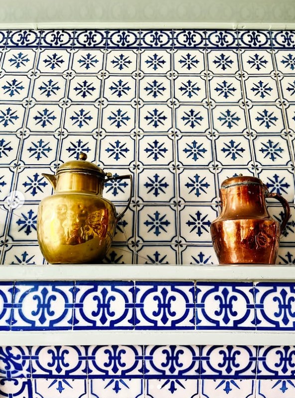 Naczynia miedziane ustawione na kominie kuchni Claude'a Moneta w Giverny, komin obłożony jest płytkami o niebieskim ornamentalnym wzorzze