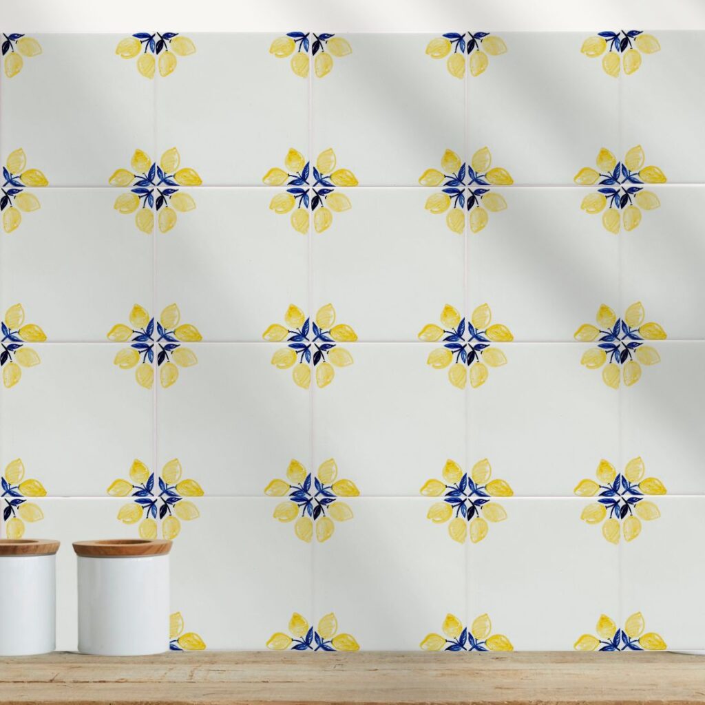 Ściana wykończona ręcznie malowanymi kafelkami ceramicznymi z cytrynowym ornamentem w jasnej kuchni.