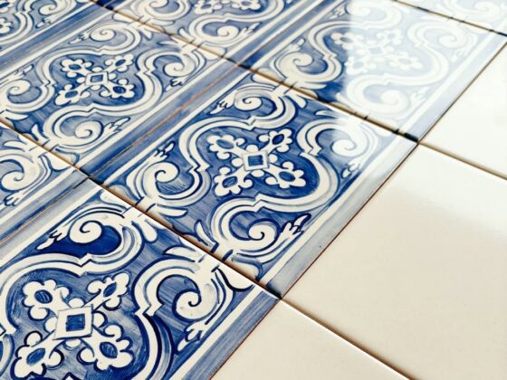 Płytki azulejos z biało-niebieskim wzorem, malowane ręcznie, ułożone po skosie i zestawione z białymi kafelkami gładkimi